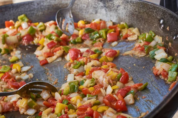 Frying pan full of vegetables that cook for the preparation of the sauce: An example of how you can cook vegetables to make a tasty sauce.