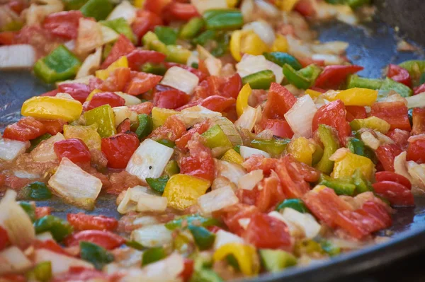 Frying pan full of vegetables that cook for the preparation of the sauce: An example of how you can cook vegetables to make a tasty sauce.