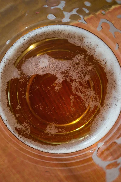 Glass of beer seen from above in which one sees the liquid inside in macro shot.