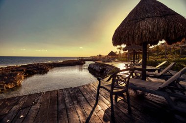 Denize bakan sahil beldesi ve Meksika 'daki Puerto Aventuras' ın doğal havuzları, alacakaranlıkta çekilen sahne..