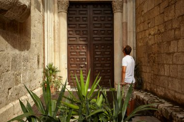 Çocuk ayakta yukarı doğru bir tarihi bir kapı önünde seyir bina