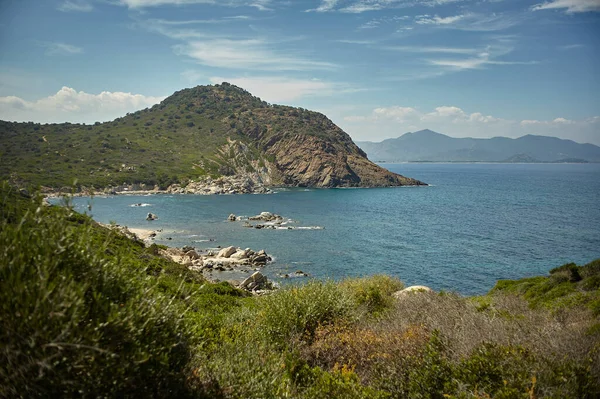 İtalya 'nın güneyindeki Sardunya' da deniz, dağlar ve Akdeniz bitkilerinin bulunduğu doğal bir körfezin panoramik manzarası, özellikle de Cala Sa Figu plajının.
