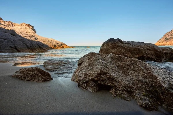 前景の海とビーチの海岸と洞窟からの出口の広角ショットを持つ美しい海 背景の地平線への海と海と合流する右の岩 休暇と自然のビーチのシンボル — ストック写真