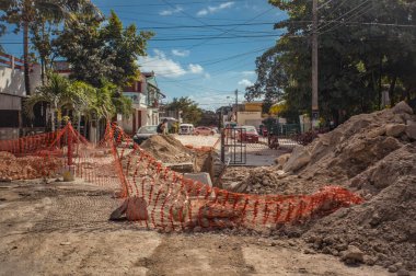 Tulum, Mexico 20 august 2022: A boy crosses a street between Tulum and Mexico, and in front of him a completely destroyed road with a long-standing construction site