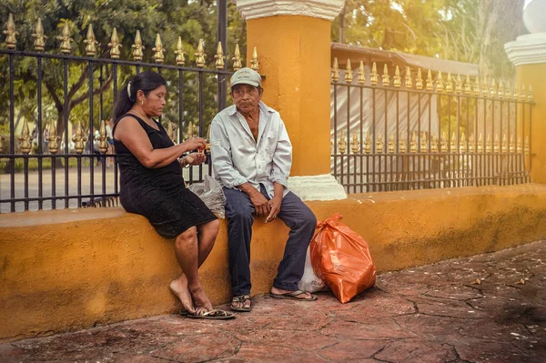 Valladolid, Mexico 20 august 2022: Couple of People sitting in a small wall waiting to pass the bus to Valladolid in Mexico