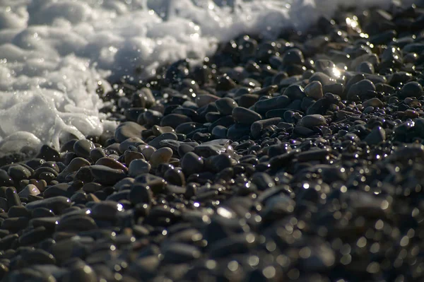 浜辺で 海の波が海岸をクラッシュに見舞わ小石の細部 — ストック写真