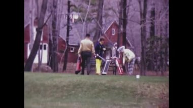 Chicago, United States march 1971: People play golf with their golf carts behind in 70s