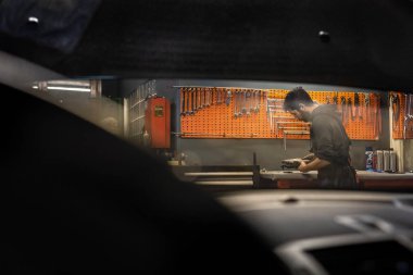 Tamirci mekanik atölyesinde çalışıyor. Araba tamir servisi.