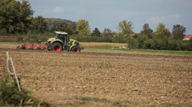 Villanova del ghebbo, İtalya, 30 Eylül 2022: tarım sistemli traktör ekili tarlayı sürerken, toprağı yeni ekin, tarım kavramı için hazırlıyor.