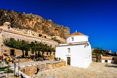 Yunanistan 'ın Mora kentindeki Monemvasia caddesindeki eski evler ve Panagia Chrysafitissa kilisesi manzarası