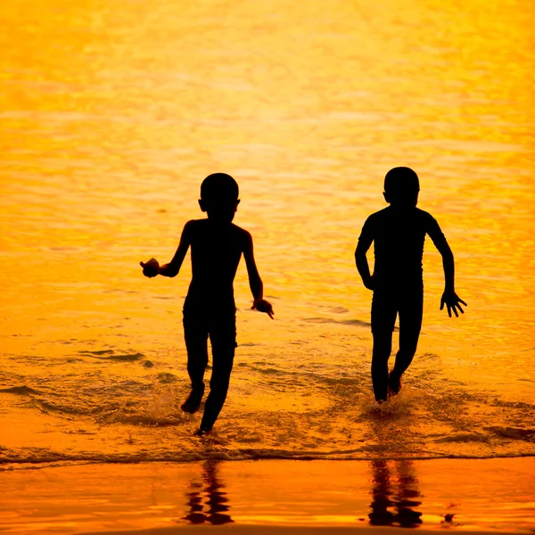 Silhouette little child on a beach at sunset — Stock Photo, Image