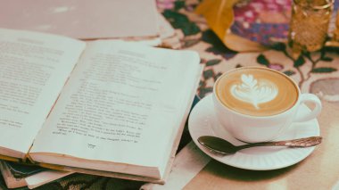 Masanın üzerinde bir fincan kahve ve defter filtresi.