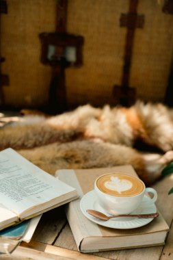 Masanın üzerinde bir fincan kahve ve defter filtresi.