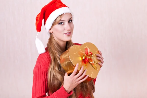 Young smiling woman with gift box looks in camera — Stock Photo, Image