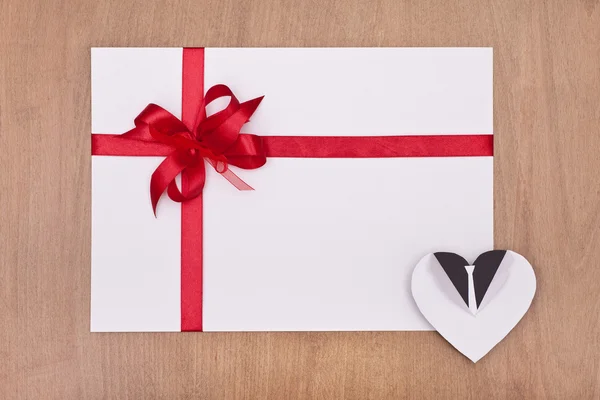 Blank card with red ribbon and white heart — Stock Photo, Image