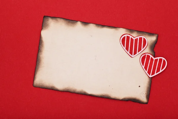 Blank grunge burnt paper and two hearts — Stock Photo, Image