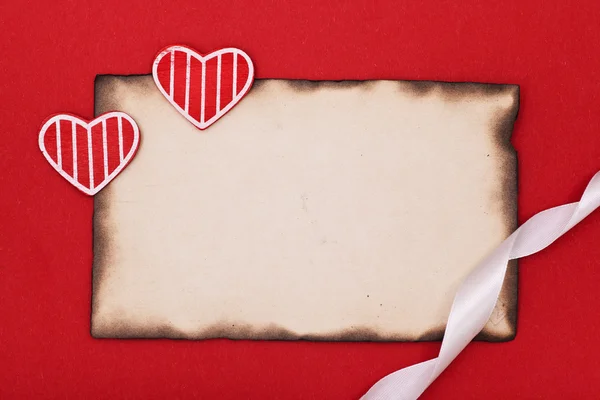 Hearts and ribbon with burnt paper — Stock Photo, Image