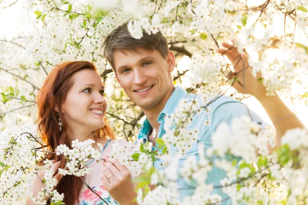 Romantic couple in flower garden — Stock Photo, Image