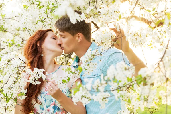 男性と女性の花の庭でキス — ストック写真