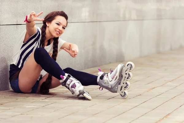 Felice adolescente su rollerblading seduto sulla strada — Foto Stock