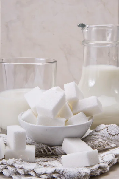 UG och glas med mjölk och socker — Stockfoto