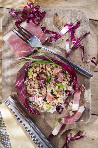 Brown rice with red radicchio and speck — Stock Photo, Image