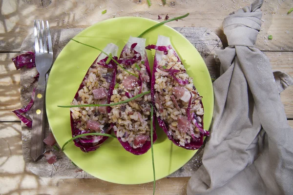 Boat of brown rice with red radicchio and speck — Stock Photo, Image