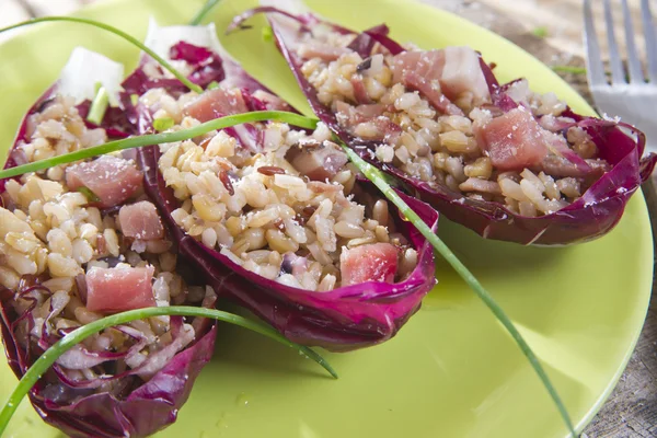 Boat of brown rice with red radicchio and speck — Stock Photo, Image