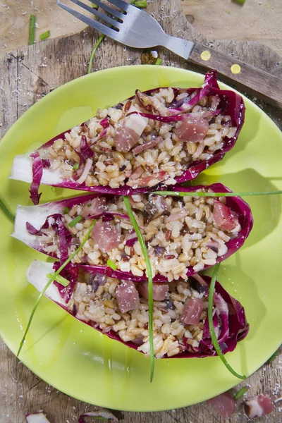 Boat of brown rice with red radicchio and speck — Stock Photo, Image