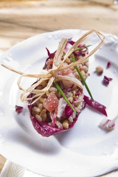 Boat of brown rice with red radicchio and speck — Stock Photo, Image