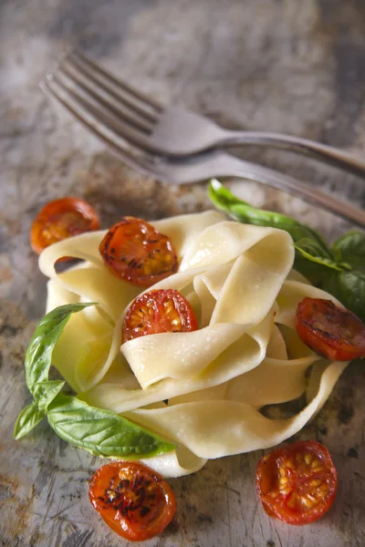 Nest of pasta with basil and tomato — Stock Photo, Image