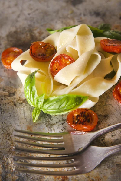 Nest of pasta with basil and tomato — Stock Photo, Image