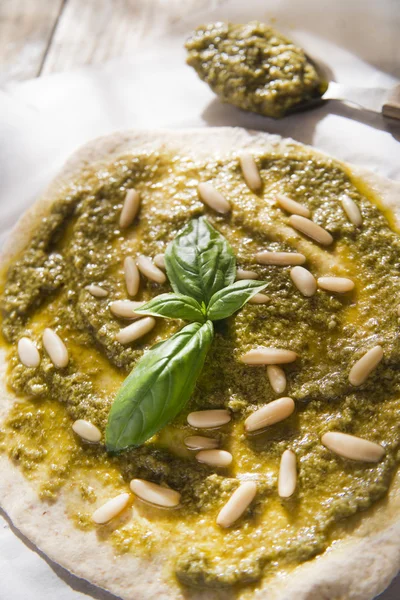 Raw pizza with pesto sauce — Stock Photo, Image