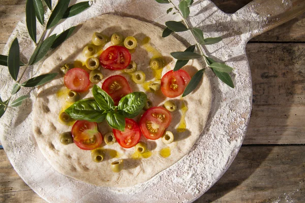 Ruwe pizza met tomaat en olijven — Stockfoto