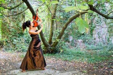 Photographic documentation of a beautiful girl playing the violin outdoors