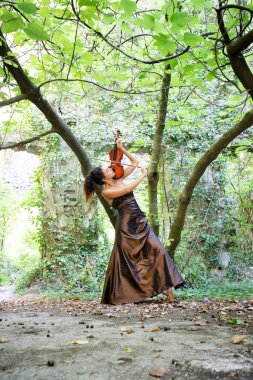 Photographic documentation of a beautiful girl playing the violin outdoors