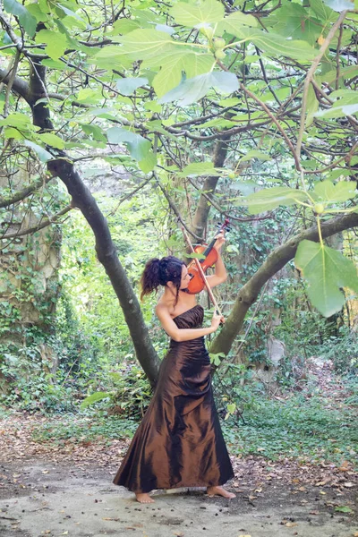 Photographic documentation of a beautiful girl playing the violin outdoors