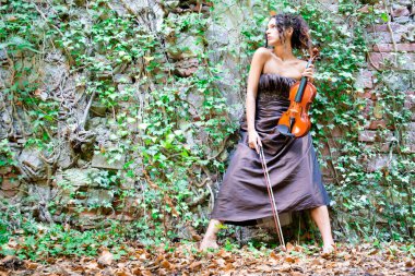 Photographic documentation of a beautiful girl playing the violin outdoors