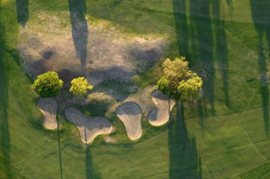 Aerial photographic documentation of a golf course taken at sunset 