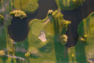 Aerial photographic documentation of a golf course taken at sunset 
