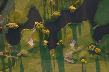Aerial photographic documentation of a golf course taken at sunset 