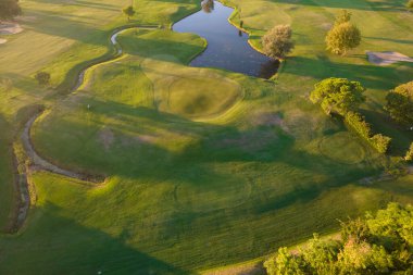 Aerial photographic documentation of a golf course taken at sunset 