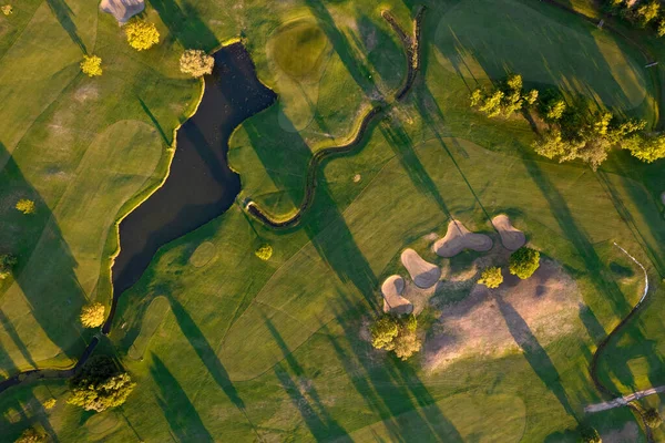 Aerial photographic documentation of a golf course taken at sunset 