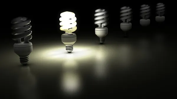 Compact fluorescent lamps in a row. One is enlightening. — Stock Photo, Image