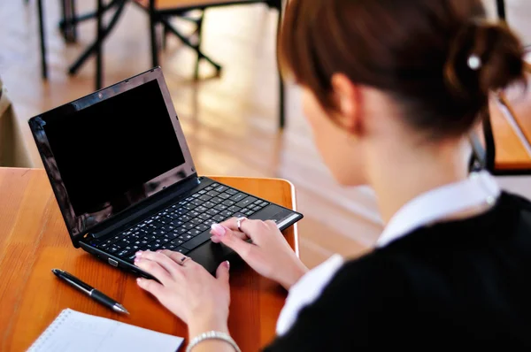 Zakenvrouw vanaf de achterkant werken met laptop in het café Stockfoto
