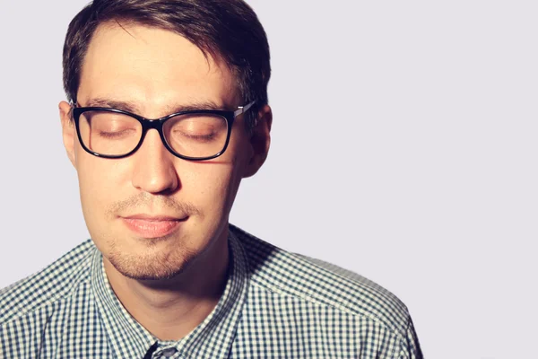 Grappige jonge man dragen van een bril met gesloten ogen Stockfoto