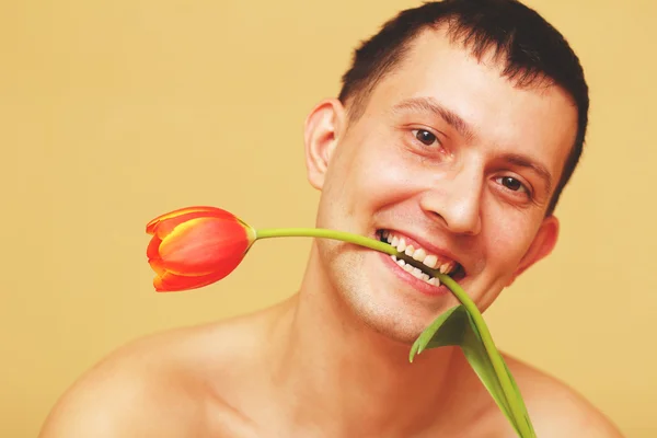 Romantische jongeman met bloemen glimlachen — Stockfoto