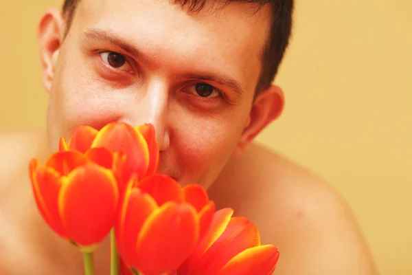 Romantisch lächelnder junger Mann mit Blumen — Stockfoto