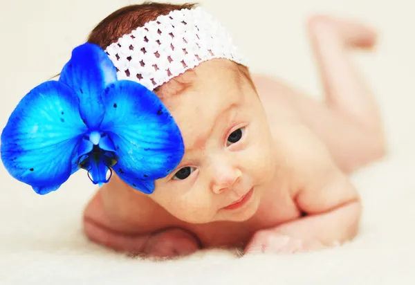 Neugeborenes Mädchen mit blauer Blume — Stockfoto