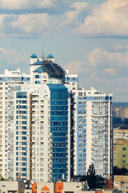 Çok katlı bir binanın çatısındaki güneş panelleri şehrin yerleşim alanının arka planına karşı. Ekolojik enerji kaynakları kavramı. Dikey görüntü. Boşluğu kopyala.